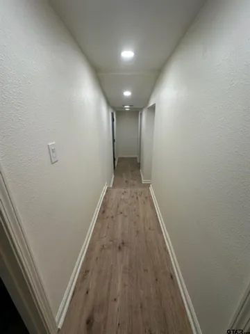 a view of hallway with wooden floor