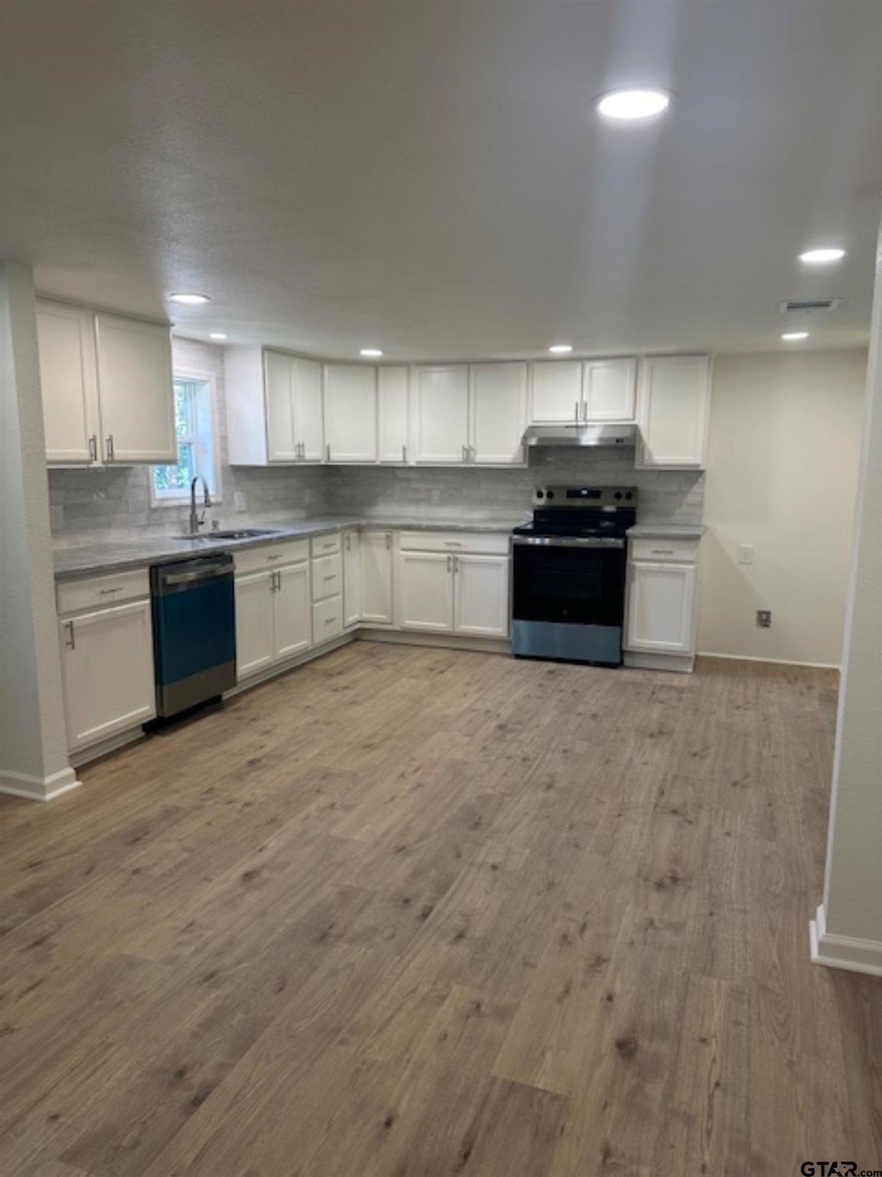 149 East Iowa Street Van, TX 75790 - Photo 12 of 17 a kitchen with stainless steel appliances kitchen island granite countertop a stove a sink and a refrigerator