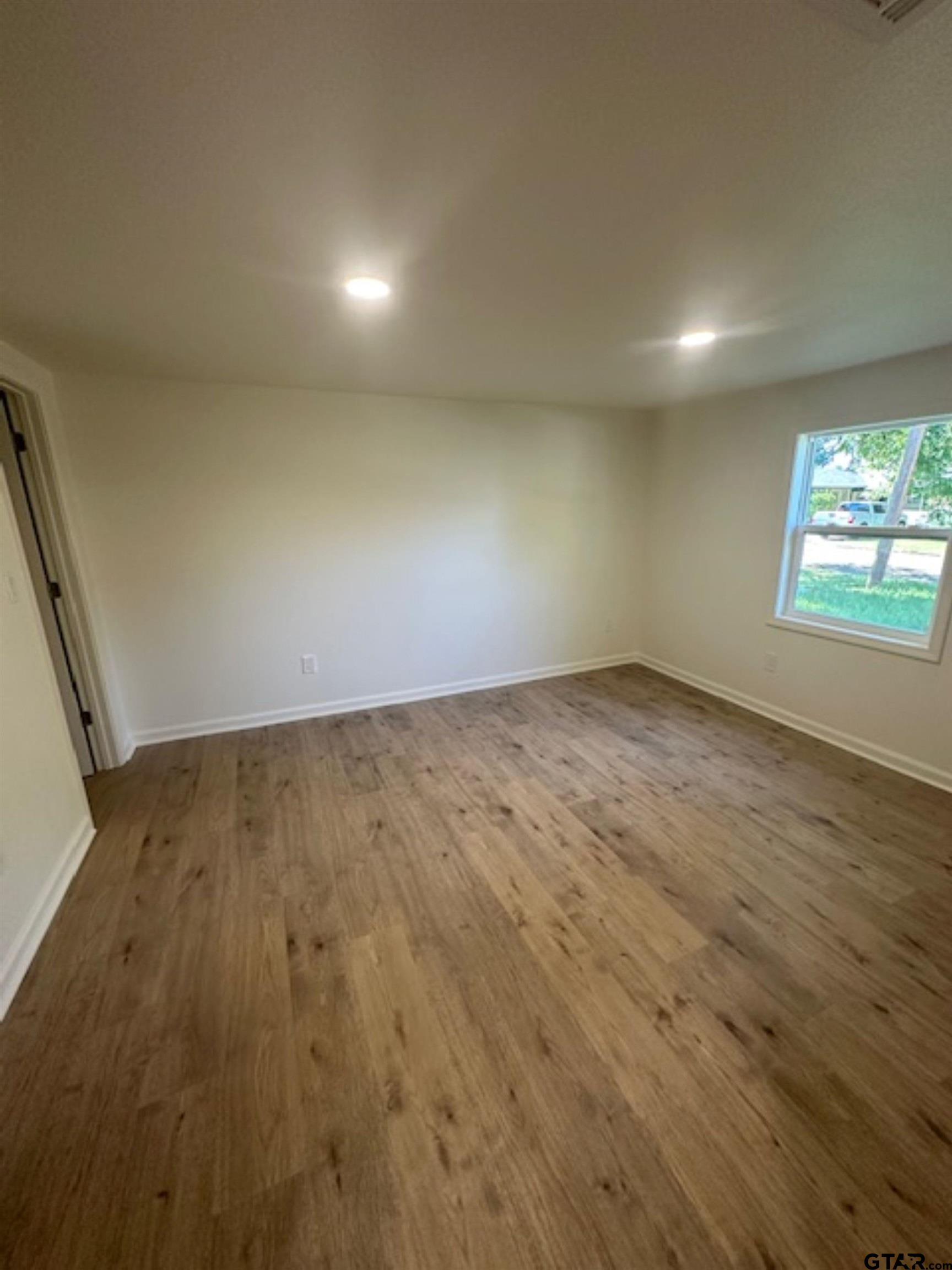 149 East Iowa Street Van, TX 75790 - Photo 15 of 17 an empty room with wooden floor and windows