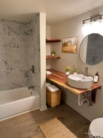 a bathroom with a sink a bathtub and a mirror