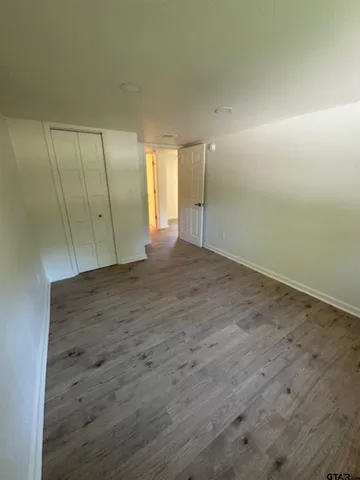 an empty room with wooden floor and sliding door