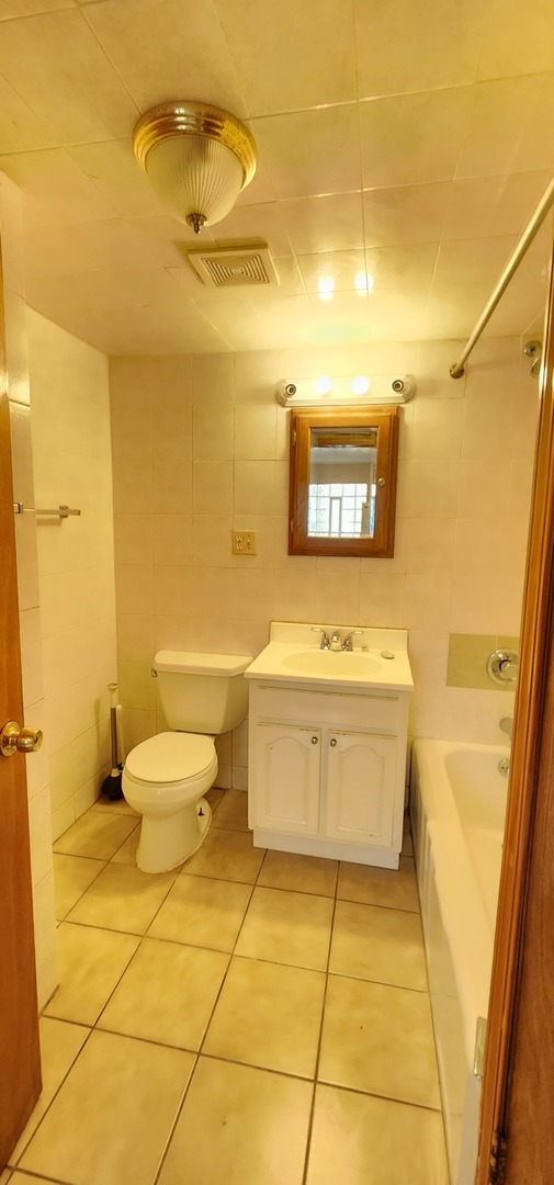 2802 South Lowe Avenue, Unit G Chicago, IL 60616 - Photo 9 of 11 a bathroom with a toilet a sink and mirror