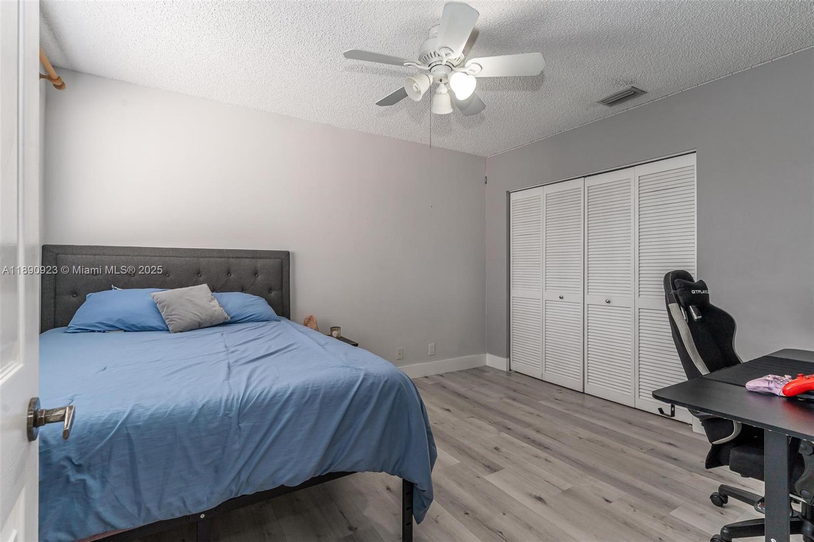 925 Briar Ridge Road Weston, FL 33327 - Photo 10 of 30 a bedroom with a bed and a chandelier