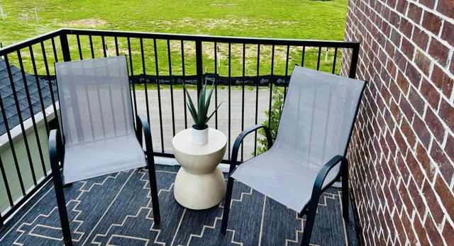 a view of a balcony with wooden floor and outdoor seating