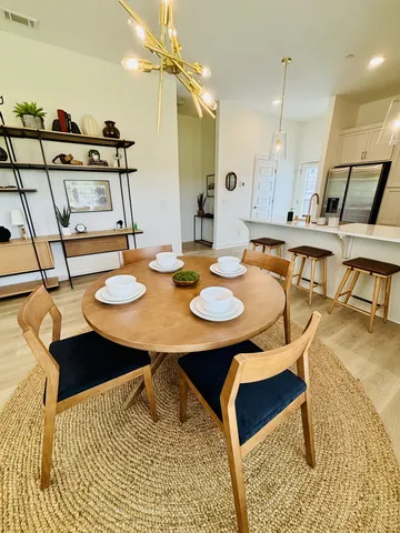 a kitchen with a table chairs and white cabinets