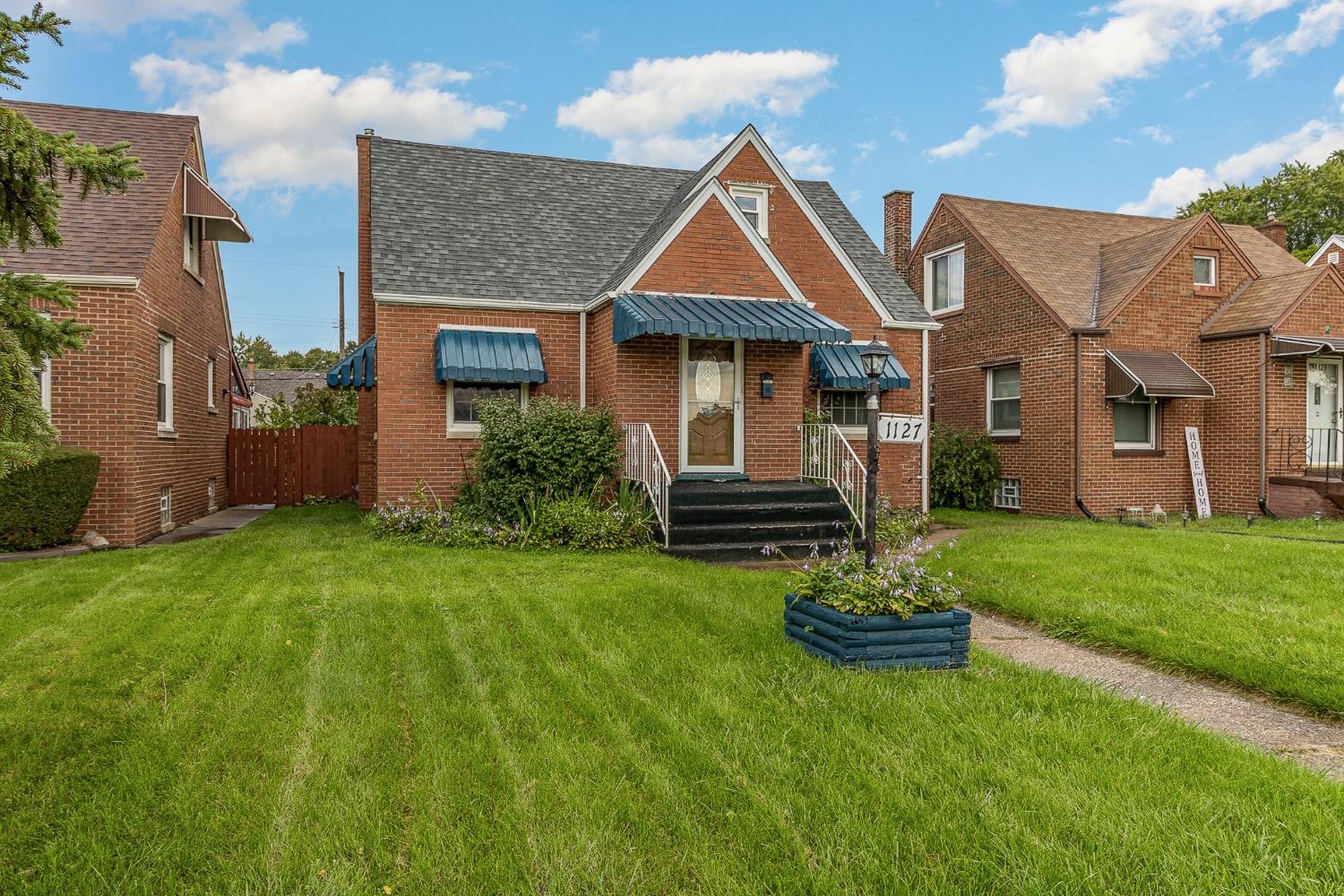 a front view of a house with a garden and plants