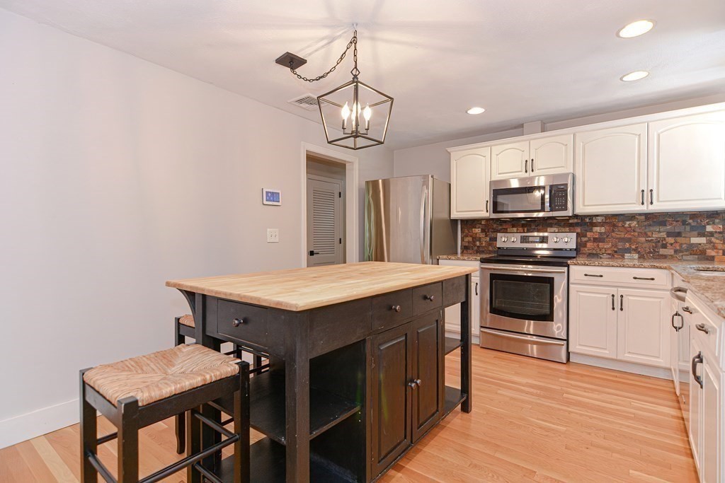 137 Howard Street Northborough, MA 01532 - Photo 11 of 41 a kitchen with a stove a sink and a refrigerator