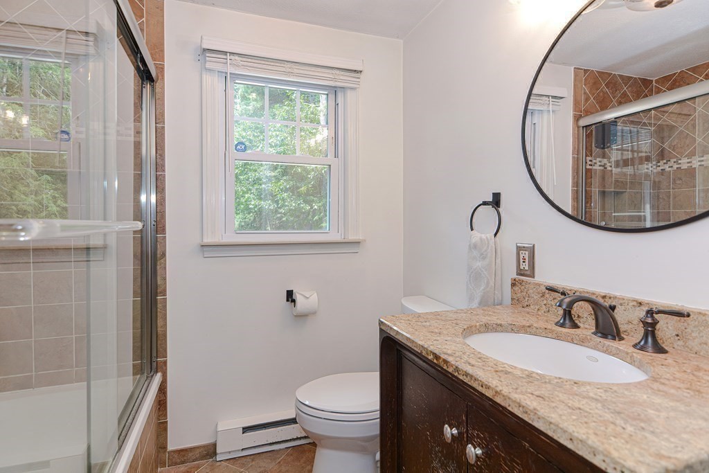 137 Howard Street Northborough, MA 01532 - Photo 17 of 41 a bathroom with a granite countertop toilet a sink and a mirror