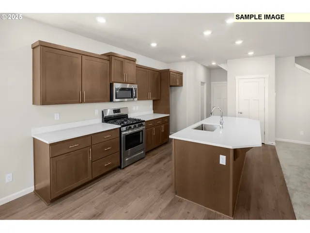 a kitchen with stainless steel appliances kitchen island granite countertop a stove a sink and a microwave