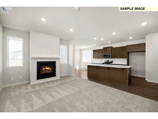 a view of kitchen with kitchen island a sink dishwasher and a fireplace with wooden floor