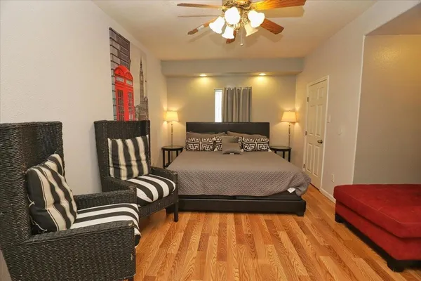 a spacious bedroom with a bed and wooden floor