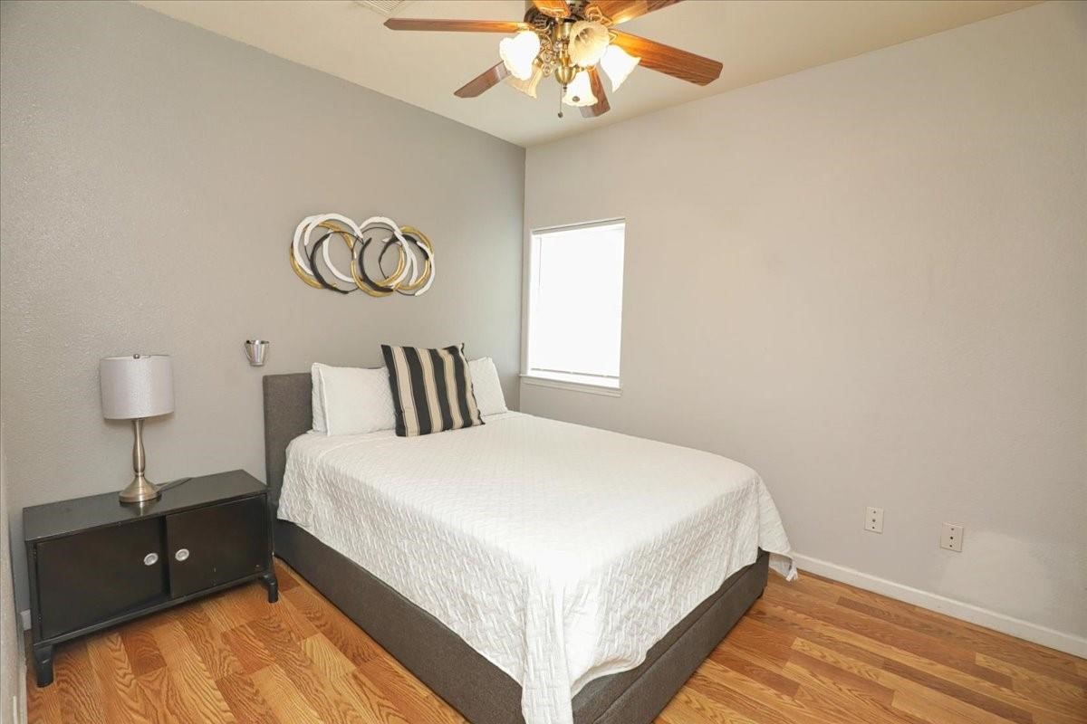 13121 Vickery Street, Unit 5 Houston, TX 77039 - Photo 26 of 40 a bedroom with a bed and a chandelier