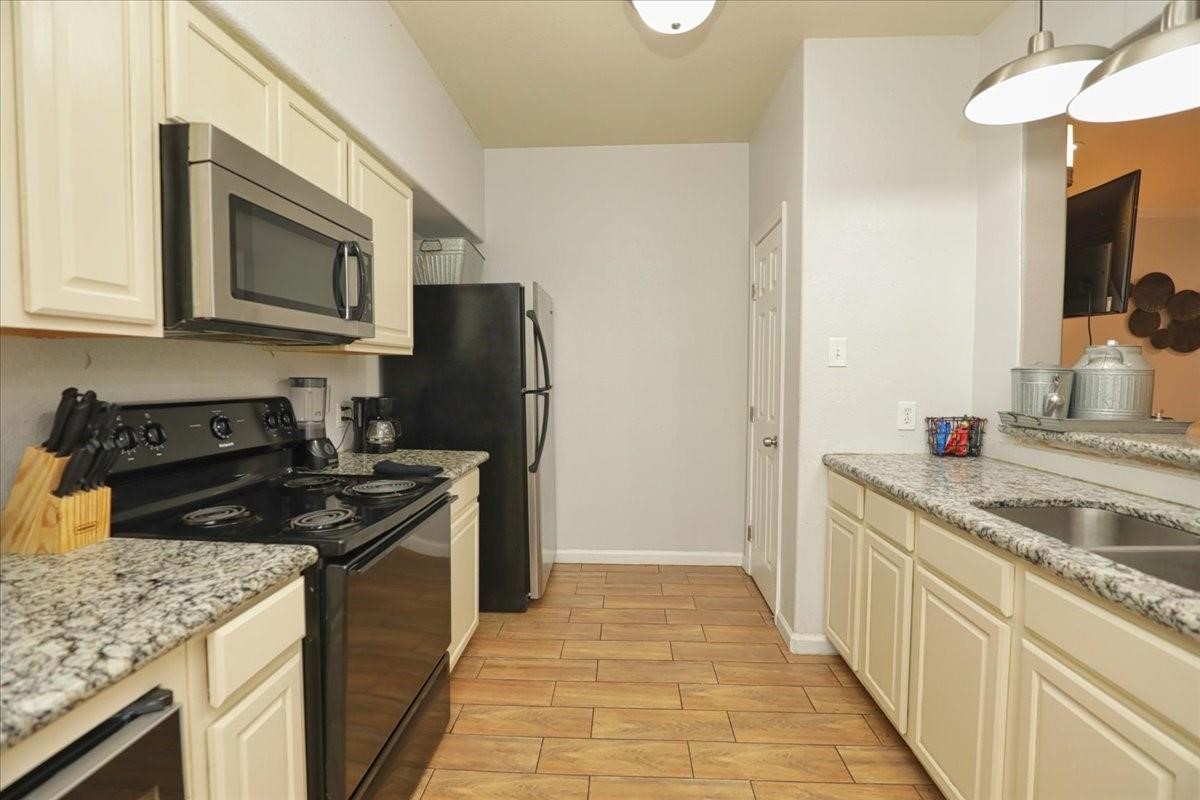 13121 Vickery Street, Unit 5 Houston, TX 77039 - Photo 28 of 40 a kitchen with stainless steel appliances granite countertop a sink stove and refrigerator