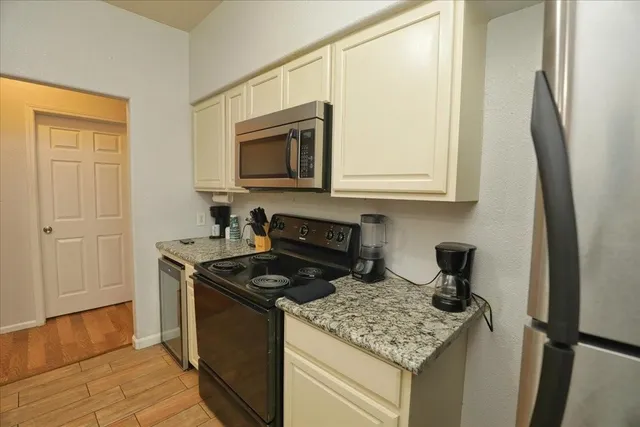 a kitchen with stainless steel appliances granite countertop a stove a sink and a microwave