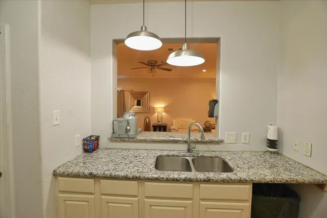 a kitchen with a granite countertop sink and a mirror
