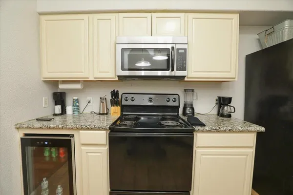 a kitchen with stainless steel appliances granite countertop a stove a microwave and a refrigerator