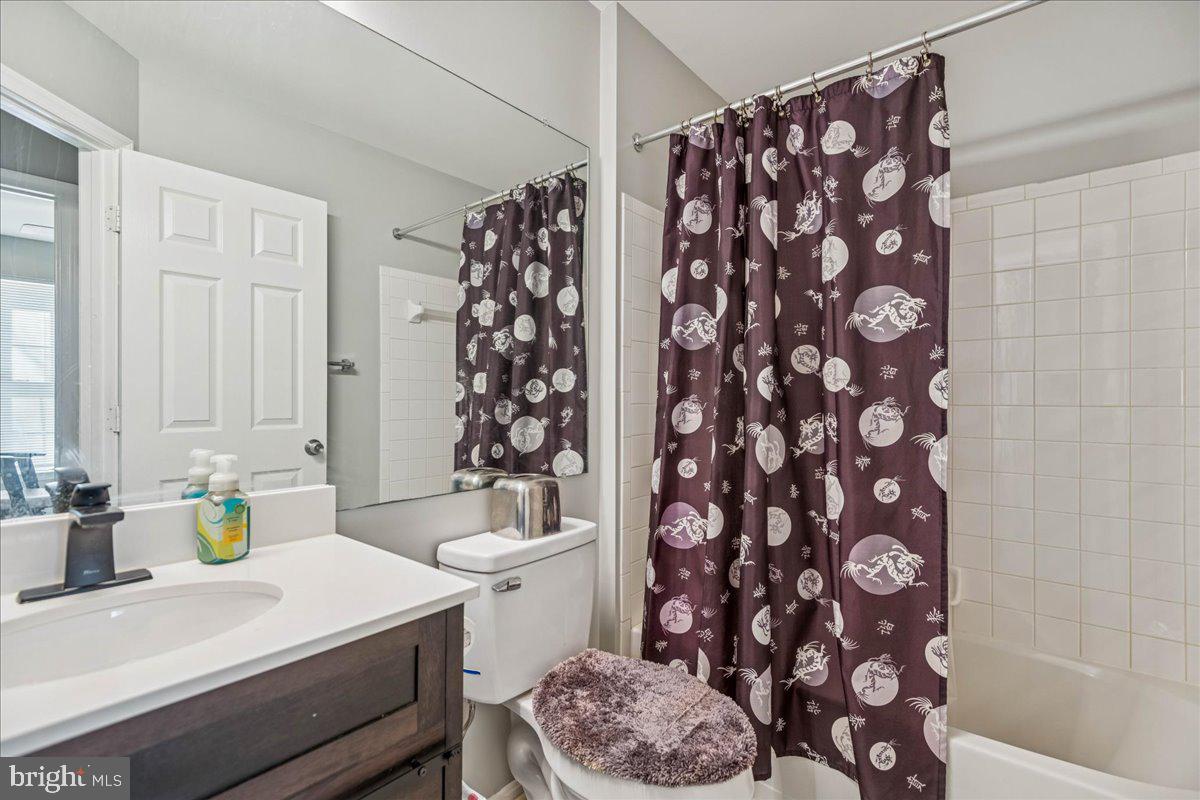 7536 Maury Road Windsor Mill, MD 21244 - Photo 26 of 36 a bathroom with a sink a toilet and shower curtain