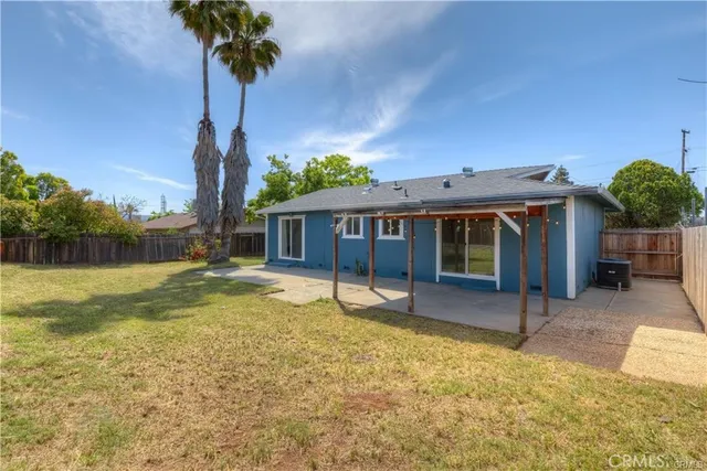 a view of a house with a yard and potted plants