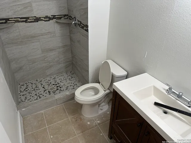 a bathroom with a toilet and a shower