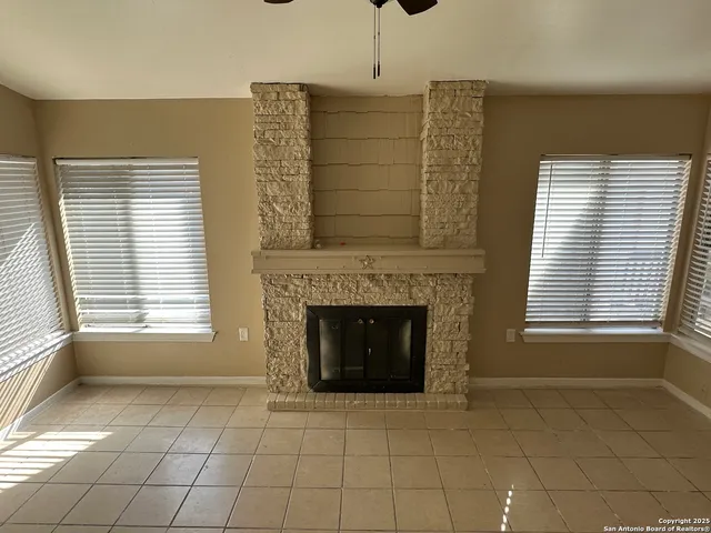 a view of an empty room with a fireplace and window