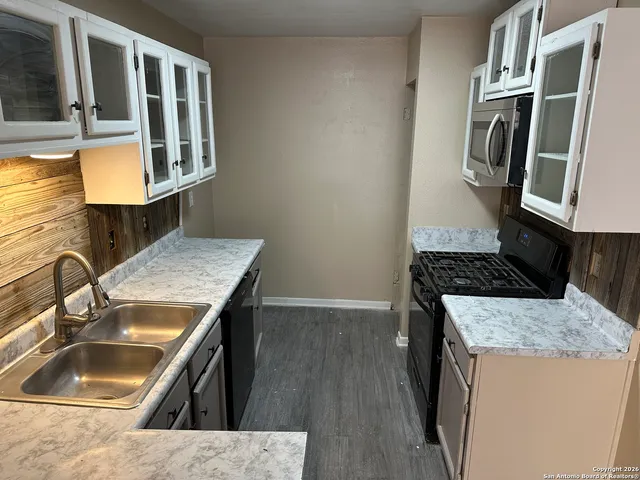 a kitchen with sink refrigerator and stove