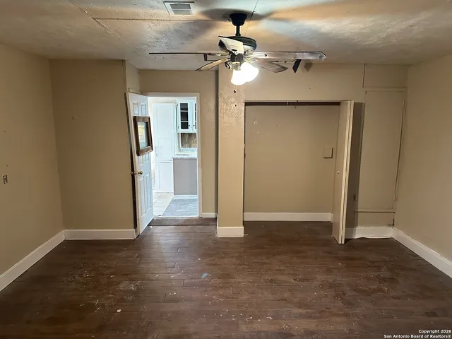 an empty room with closet and a chandelier fan
