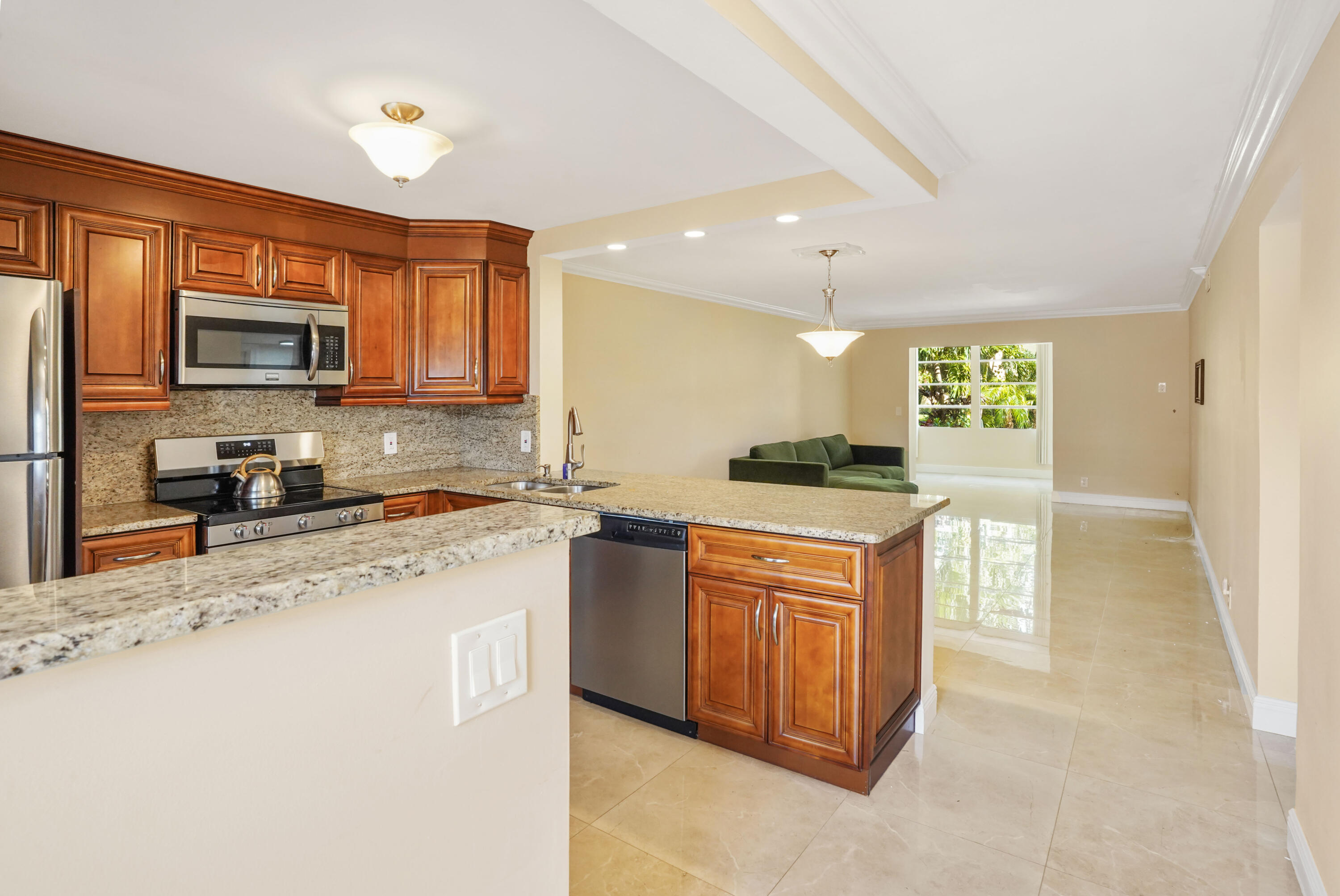 a kitchen with stainless steel appliances granite countertop a stove sink microwave and refrigerator