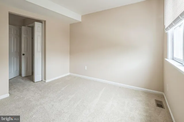 an empty room with windows and closet