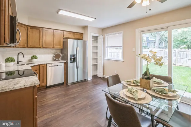 a kitchen with stainless steel appliances granite countertop wooden floor and large window