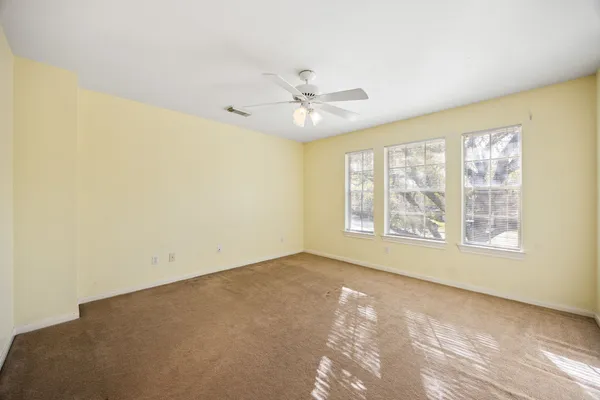 an empty room with a window and a ceiling fan
