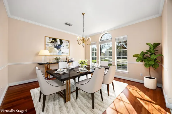 a dining room with furniture potted plants and wooden floor
