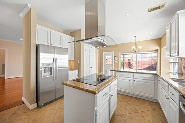 a kitchen with granite countertop a sink stove and refrigerator