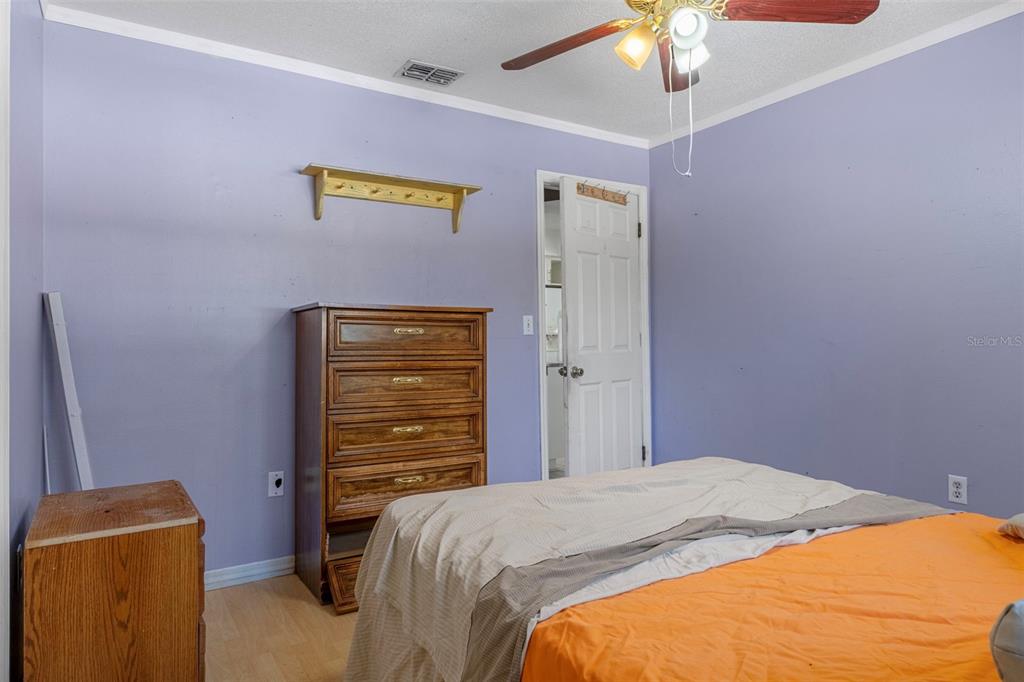 9267 Gibralter Street Spring Hill, FL 34608 - Photo 30 of 50 a bedroom with a bed and a chandelier