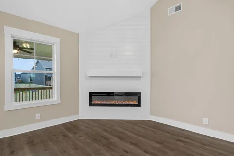 a view of an empty room with a window and fire place