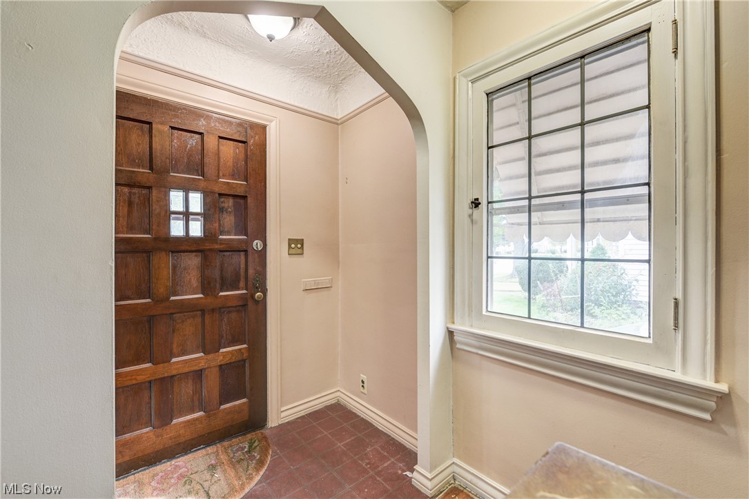 4709 Snow Road Cleveland, OH 44134 - Photo 3 of 35 Foyer entrance featuring dark tile floors and a textured ceiling