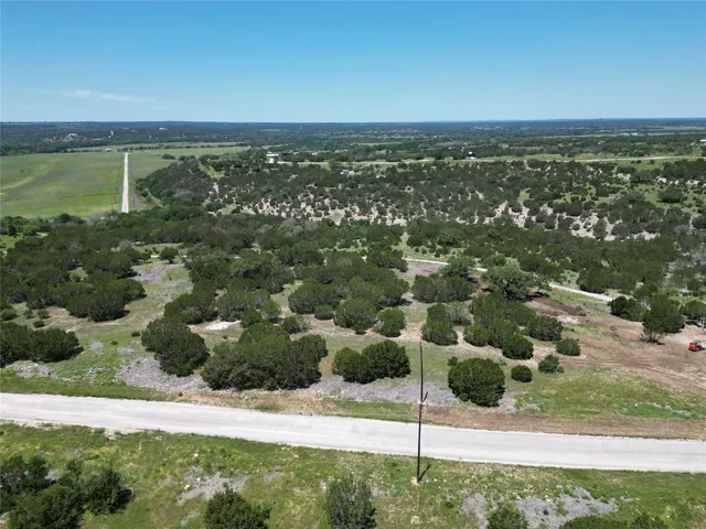 an aerial view of residential houses with outdoor space and trees