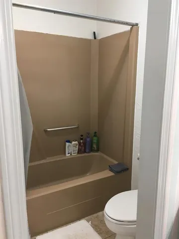 a bathroom with a toilet and a bath tub