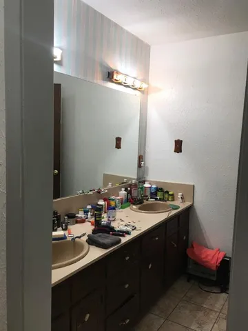 a bathroom with a double vanity sink and a mirror