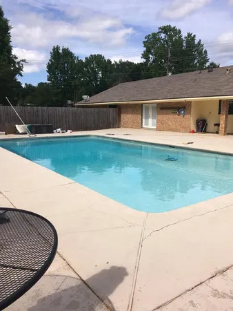 a view of swimming pool with deck and yard