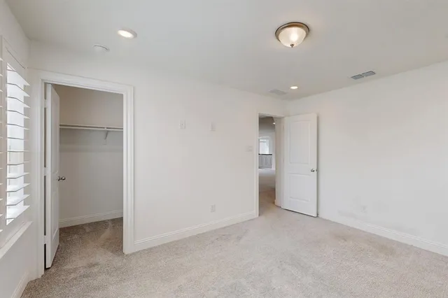 an empty room with closet and windows