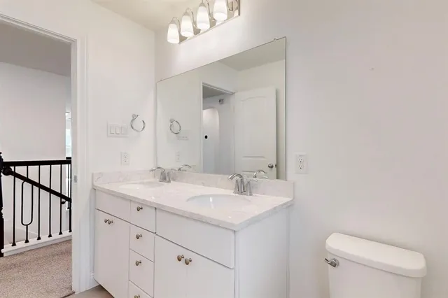 a bathroom with a sink a toilet a mirror and vanity