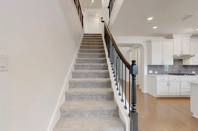 a view of staircase and kitchen with wooden floor
