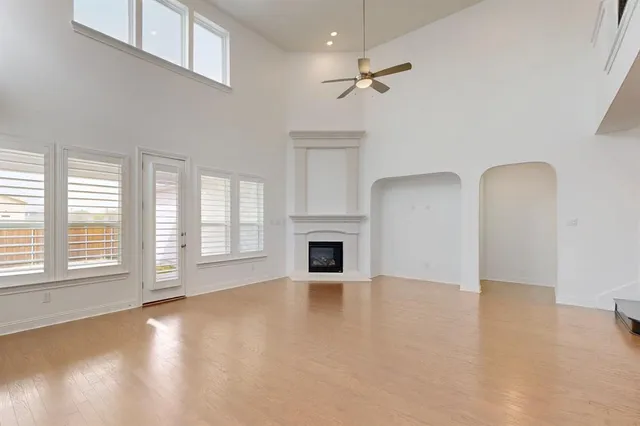 wooden floor fireplace and windows in an empty room