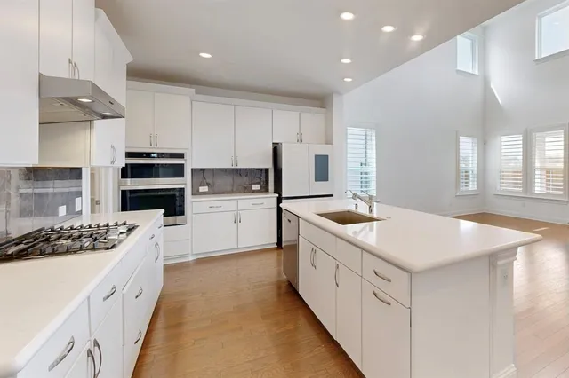 a kitchen with stainless steel appliances kitchen island granite countertop a sink stove and cabinets