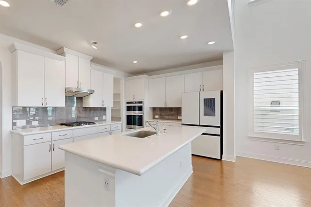 a kitchen with refrigerator cabinets and wooden floor