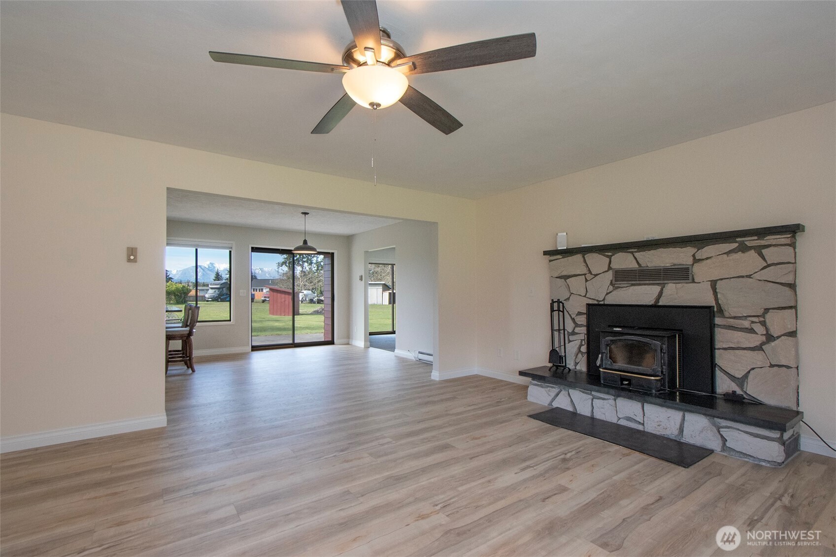 272 Grandview Drive Sequim, WA 98382 - Photo 8 of 40 a view of an empty room with wooden floor fireplace and a window