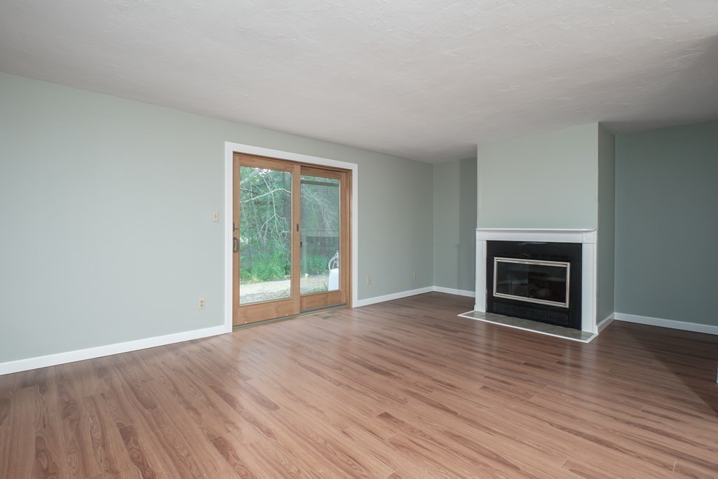 4 Shellback Way, Unit A4 Mashpee, MA 02649 - Photo 13 of 30 an empty room with wooden floor fireplace and windows