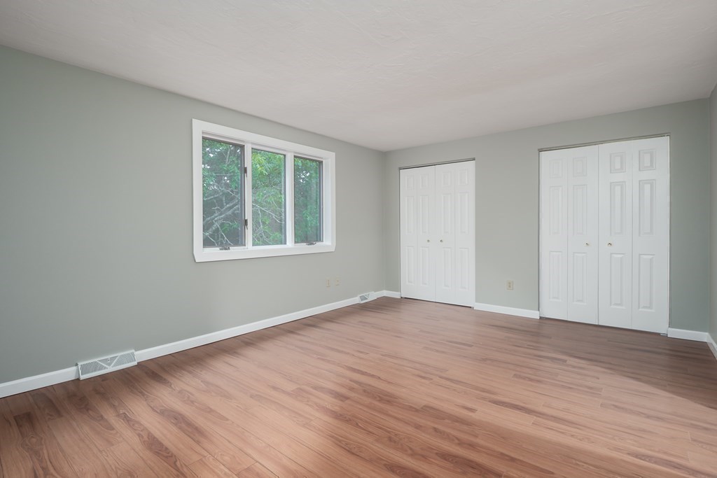 4 Shellback Way, Unit A4 Mashpee, MA 02649 - Photo 16 of 30 a view of an empty room with wooden floor and a window