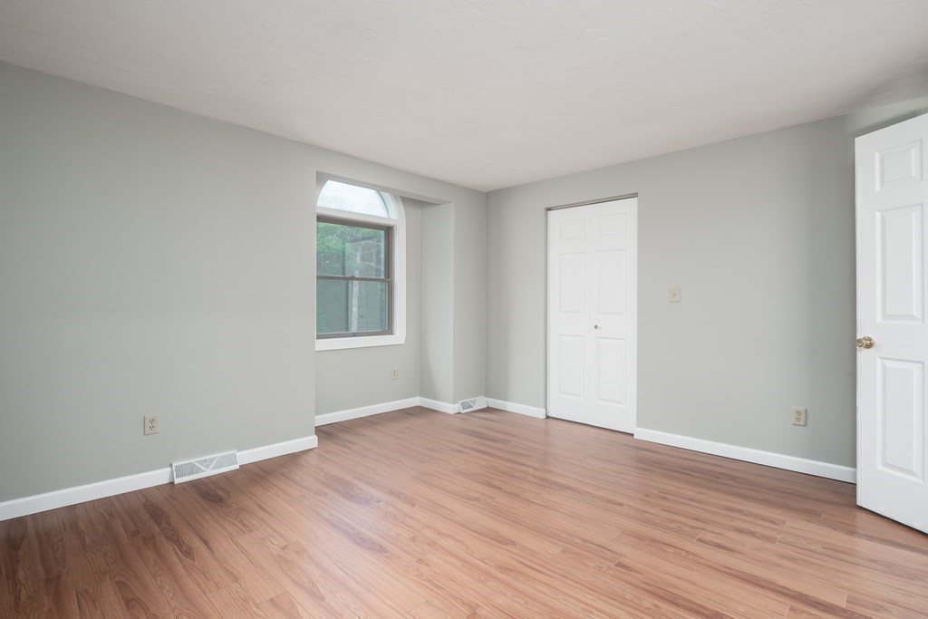 4 Shellback Way, Unit A4 Mashpee, MA 02649 - Photo 19 of 30 a view of an empty room with wooden floor and a window