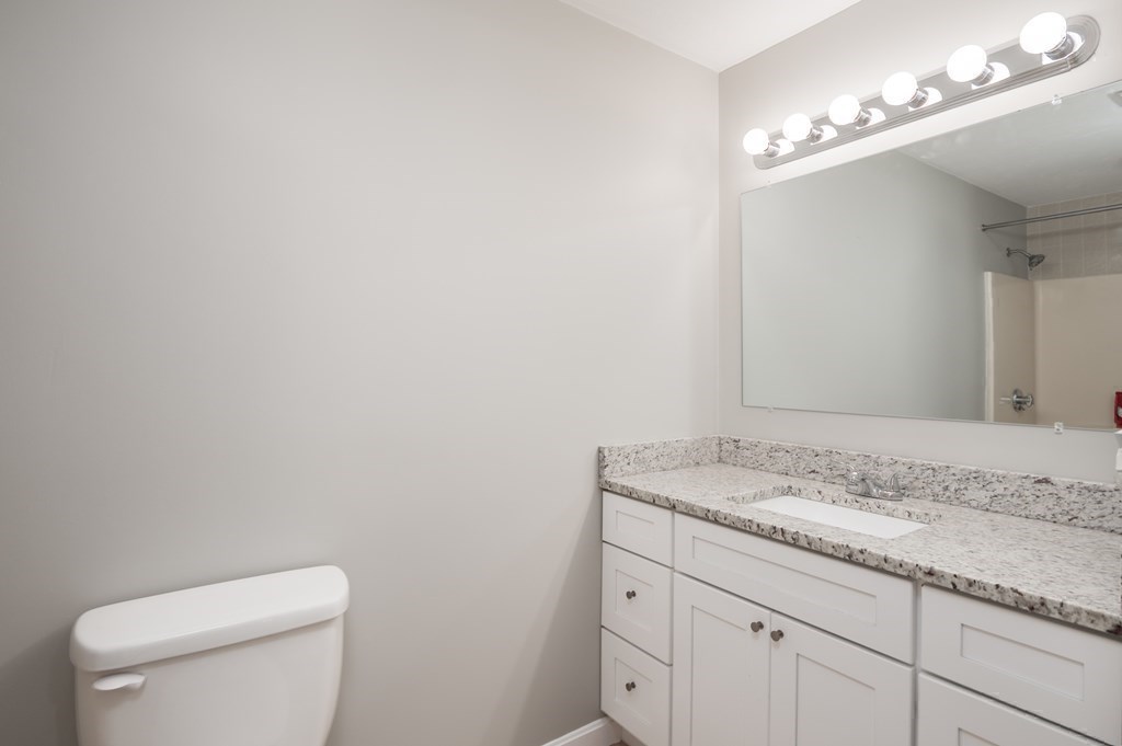 4 Shellback Way, Unit A4 Mashpee, MA 02649 - Photo 20 of 30 a bathroom with a granite countertop sink and a mirror